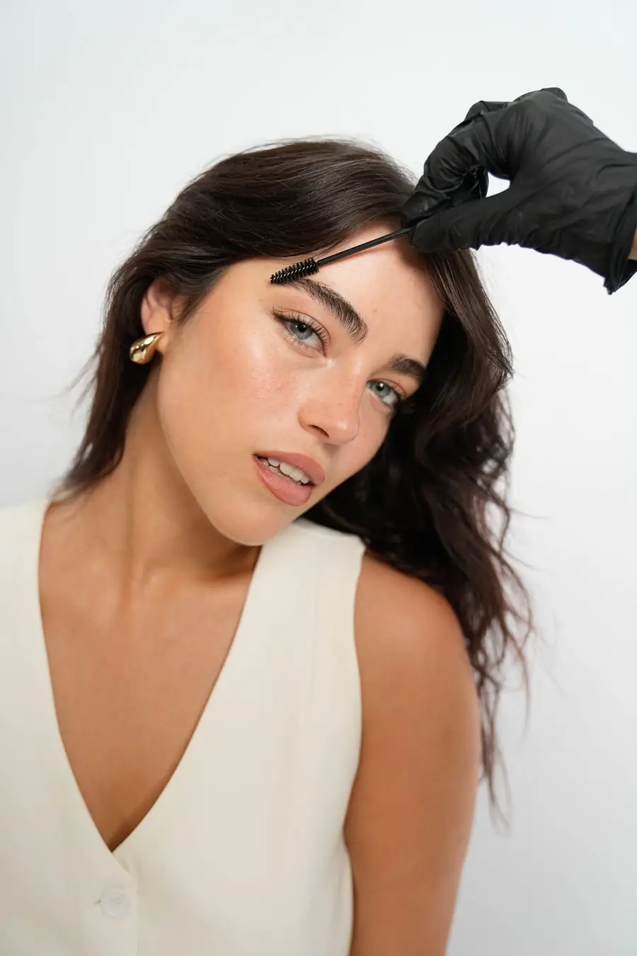 Brushed brow sendo feito com escovinha penteando os fios da sobrancelha para cima — Tatuapé